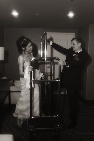 A couple dances and celebrates near a metal railing in dramatic lighting.