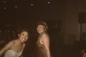 People dancing and celebrating at a dimly lit reception.