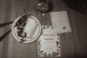 Wedding invitation and menu card displayed next to a partially eaten dessert plate.