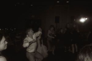 Dark dance floor with silhouettes of people dancing.