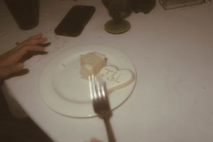 Empty dinner plates and utensils on a white tablecloth.