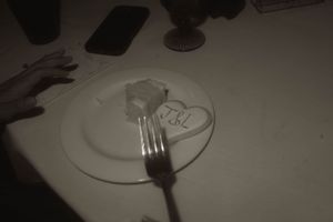 Dinner plates and utensils arranged on a white tablecloth.