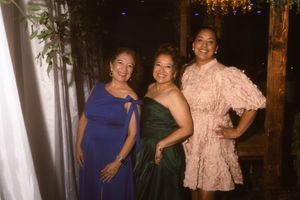 Guests in colorful formal attire posing at an evening event.