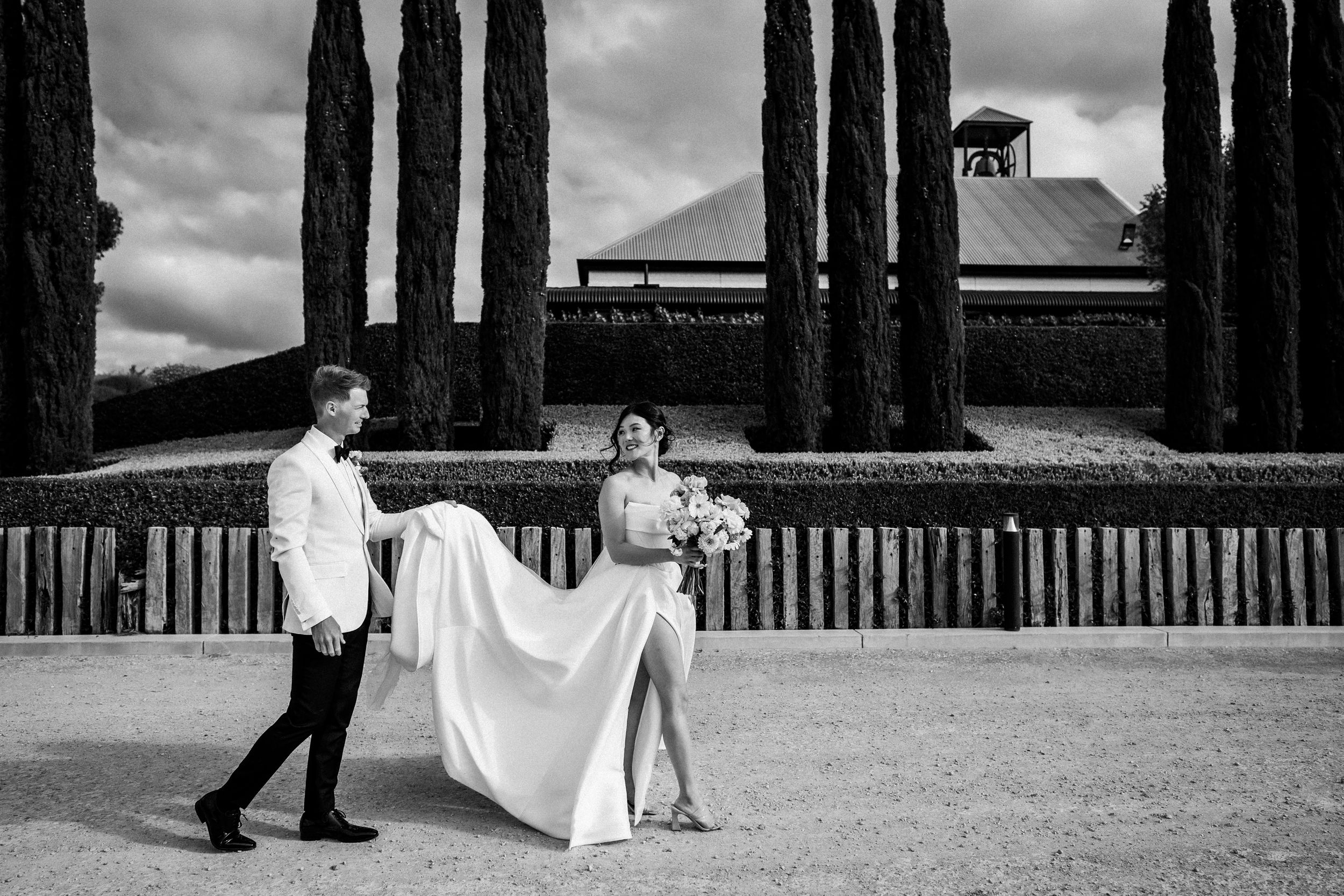 Black and white wedding photos with dramatic cypress trees creating elegant architectural lines.