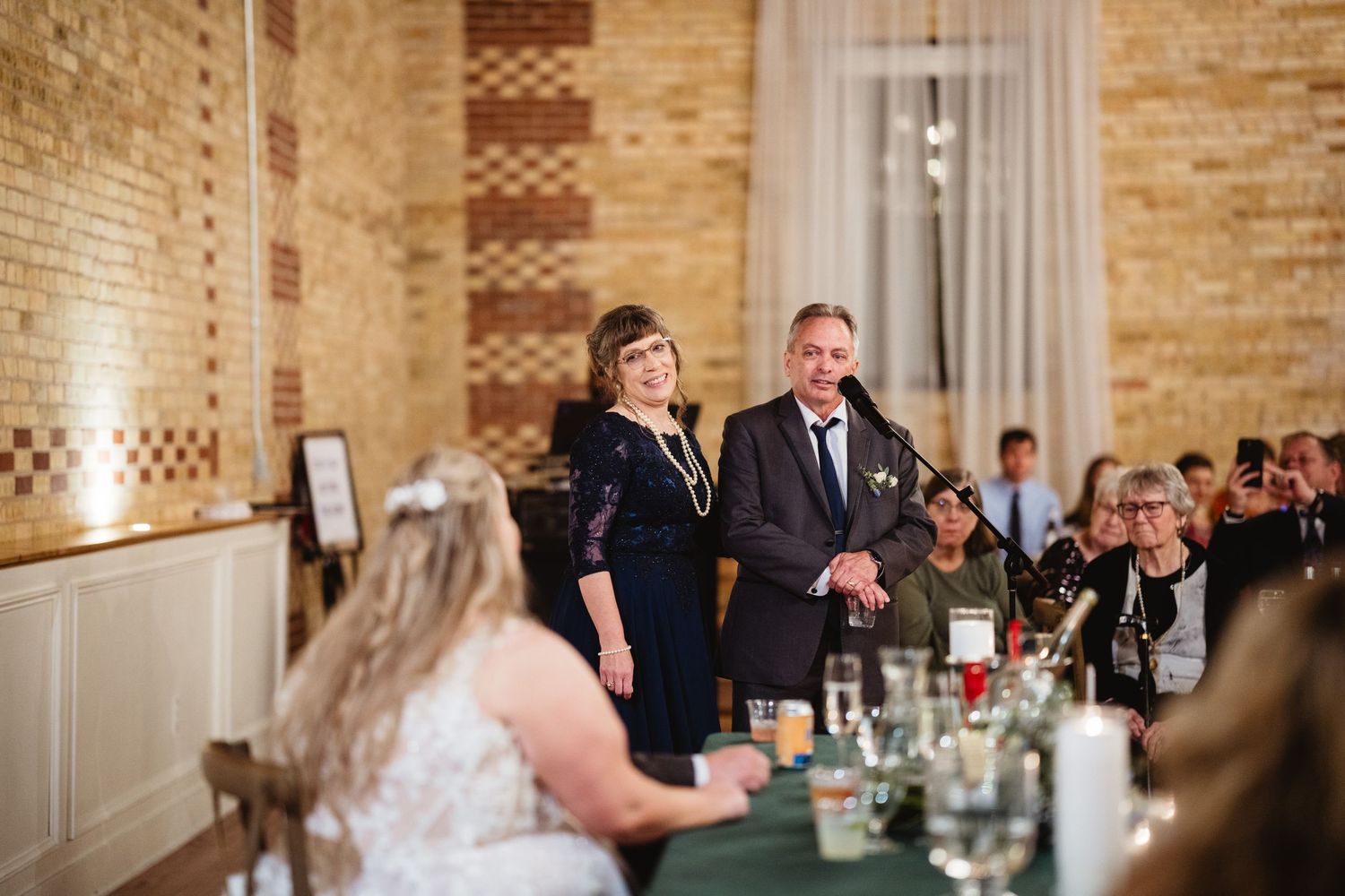 Wedding celebration in an industrial-chic space with exposed brick walls and elegant table settings.