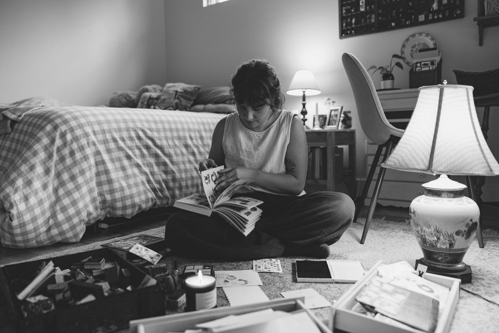 A series of black and white photographs showing someone working at a desk with a laptop and table lamp.