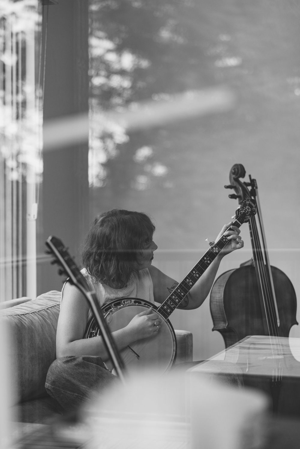 Musicians playing string instruments in a black and white photograph showing a series of silhouetted figures.
