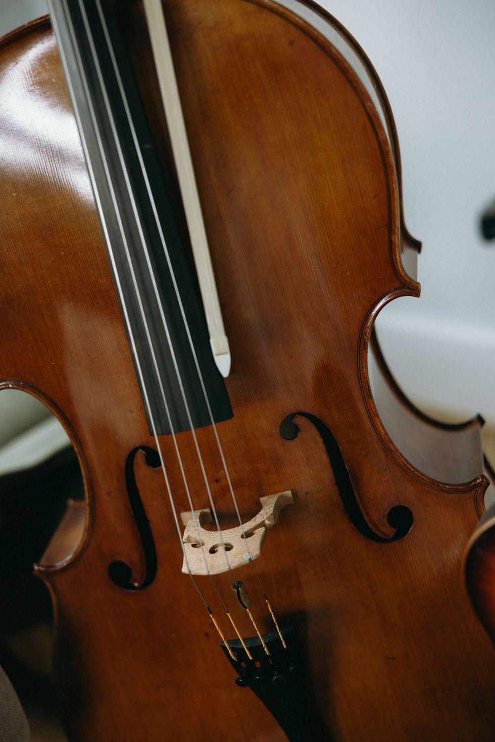 Close-up sequence of a wooden violin showing the curved body, f-holes, and rich brown finish from different angles.