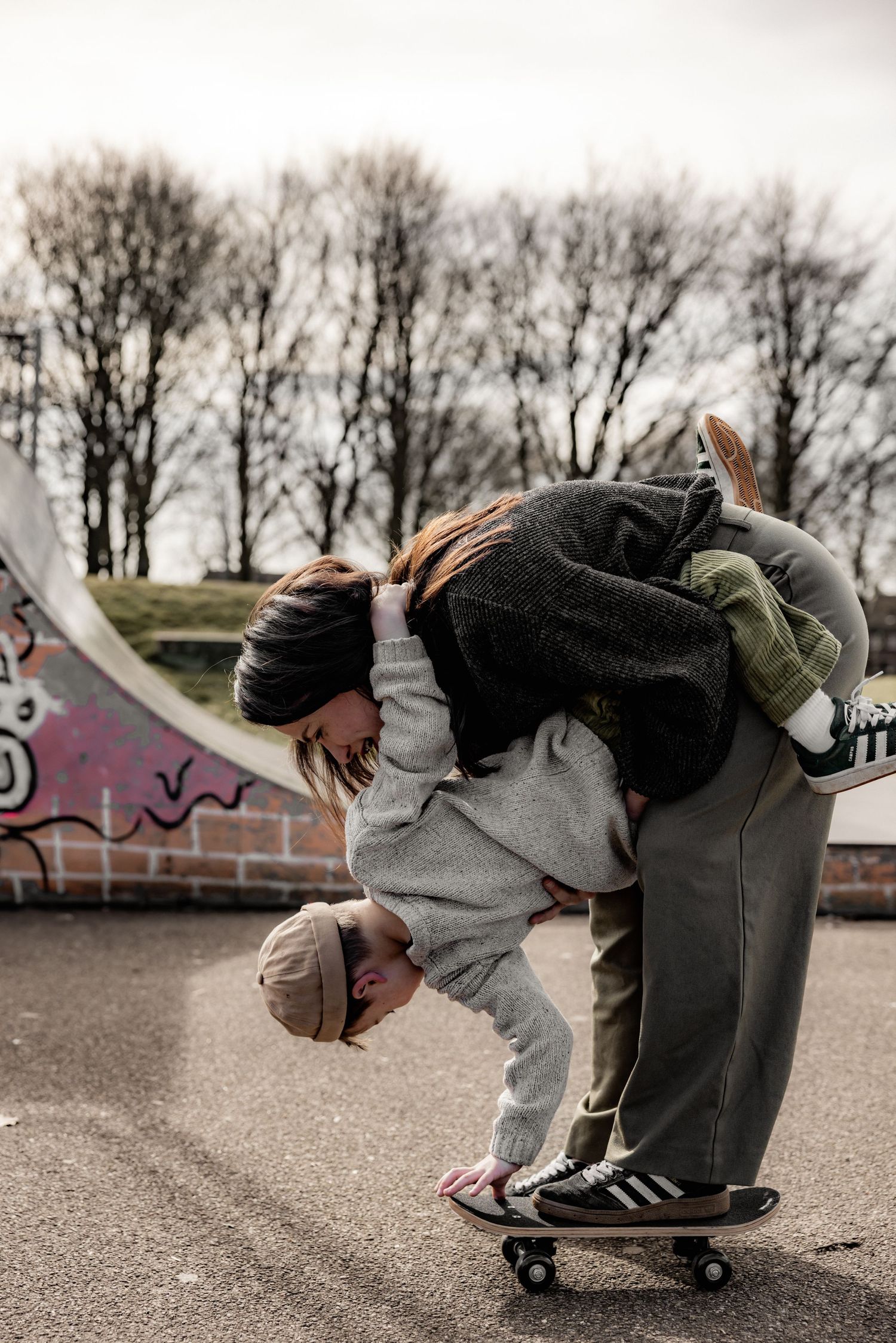 Action sequence of someone performing tricks on a skateboard at an outdoor skate park.