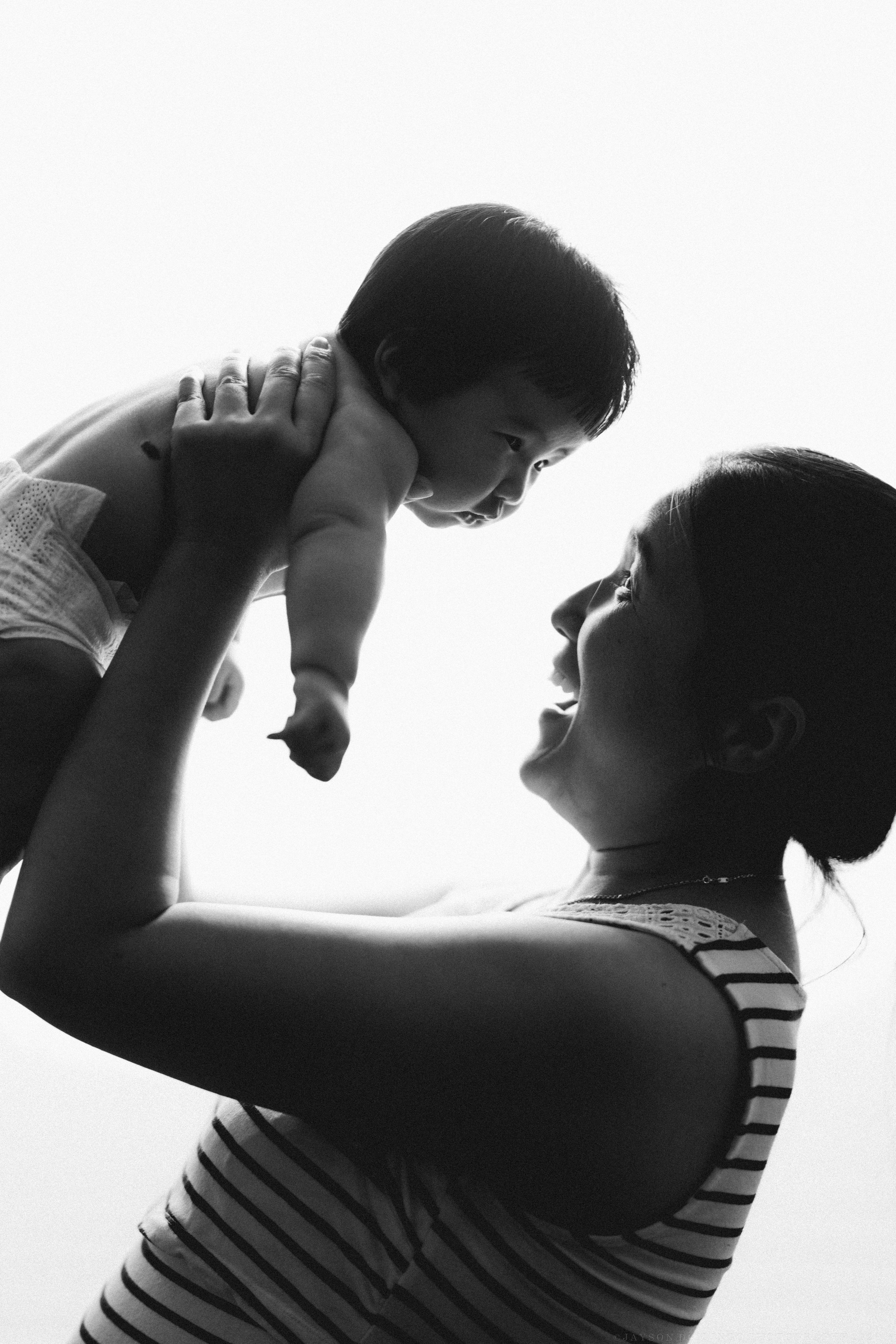 A series of silhouettes show a parent lifting and playing with a child against a white background.