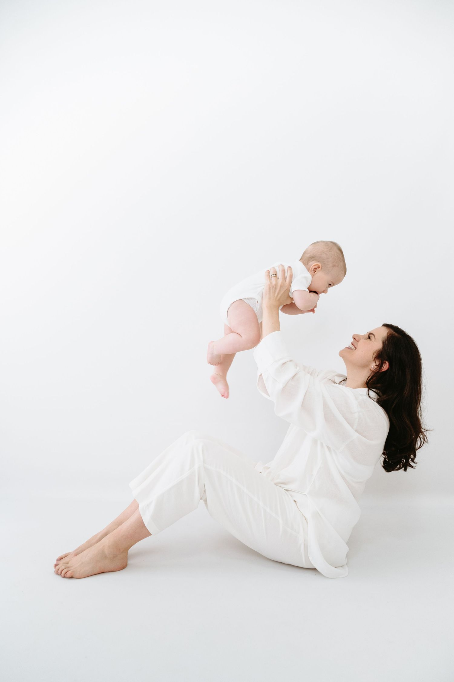 A tender moment captured in white as a mother and baby touch noses in three progressive shots.