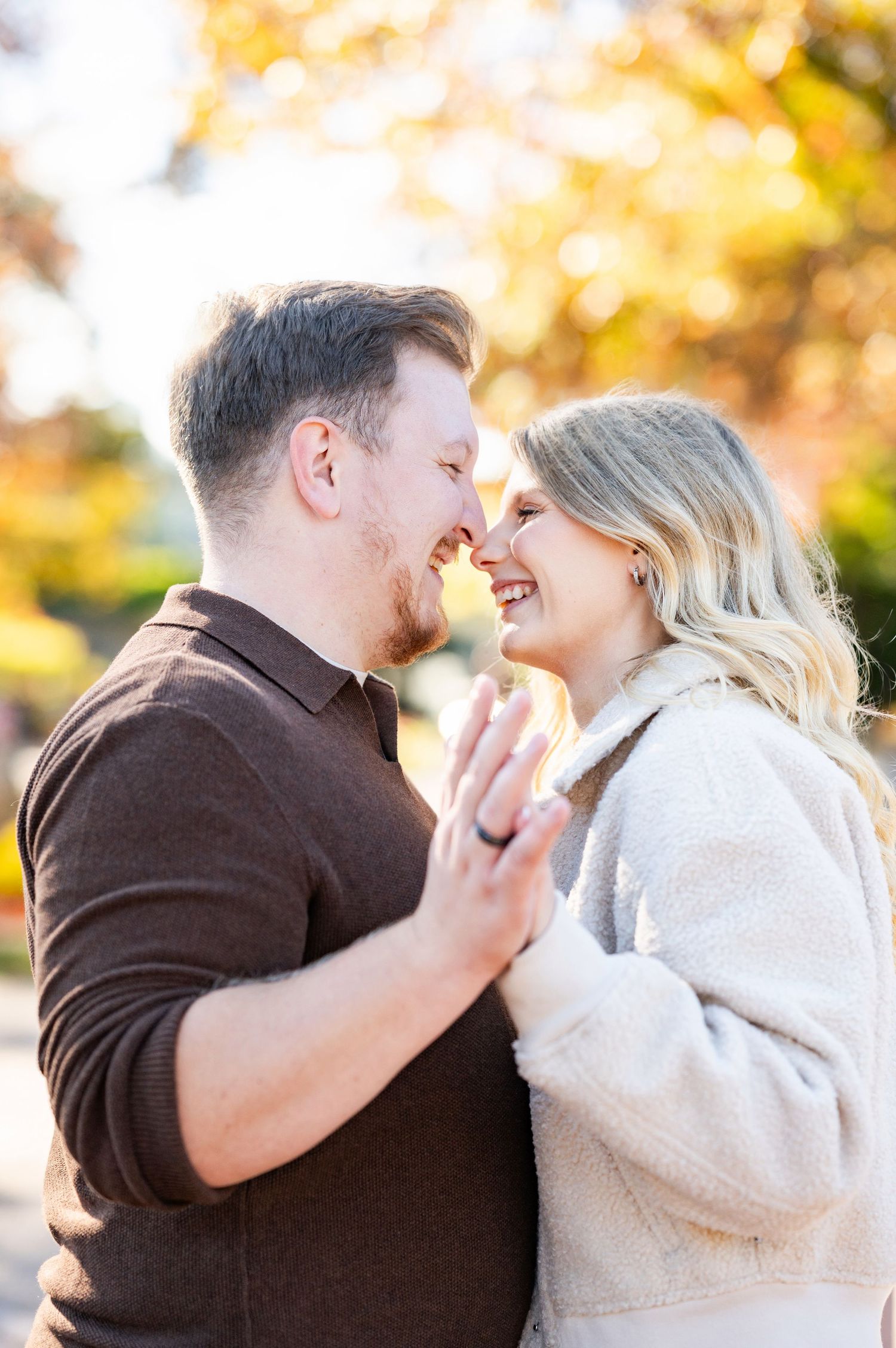 A couple shares a tender moment in a series of photos taken outdoors during golden autumn light.