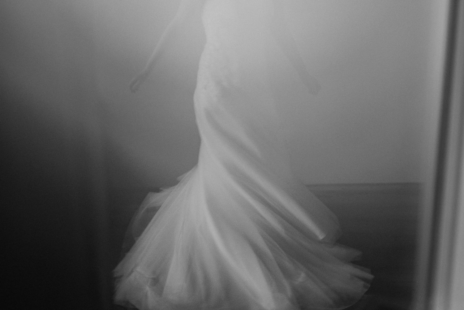Artistic black and white silhouette of a flowing wedding dress.