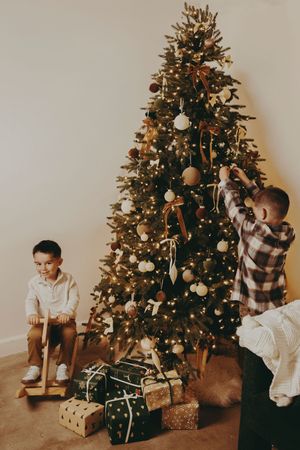 A series of vintage-style photos showing a decorated Christmas tree with wrapped presents underneath in warm sepia tones.