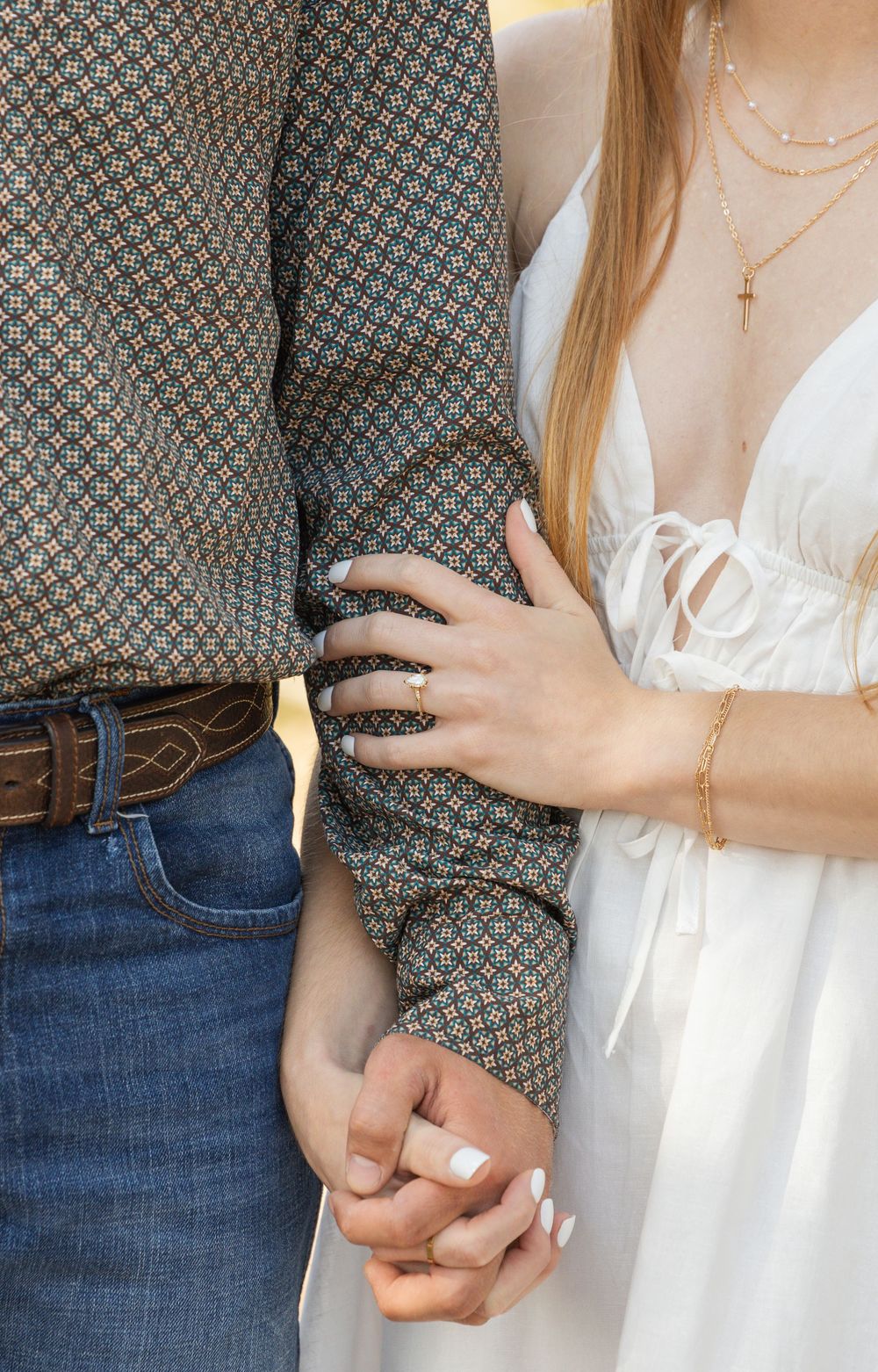 A series of close-up shots showing two people holding hands in different poses, wearing casual denim and white clothing.