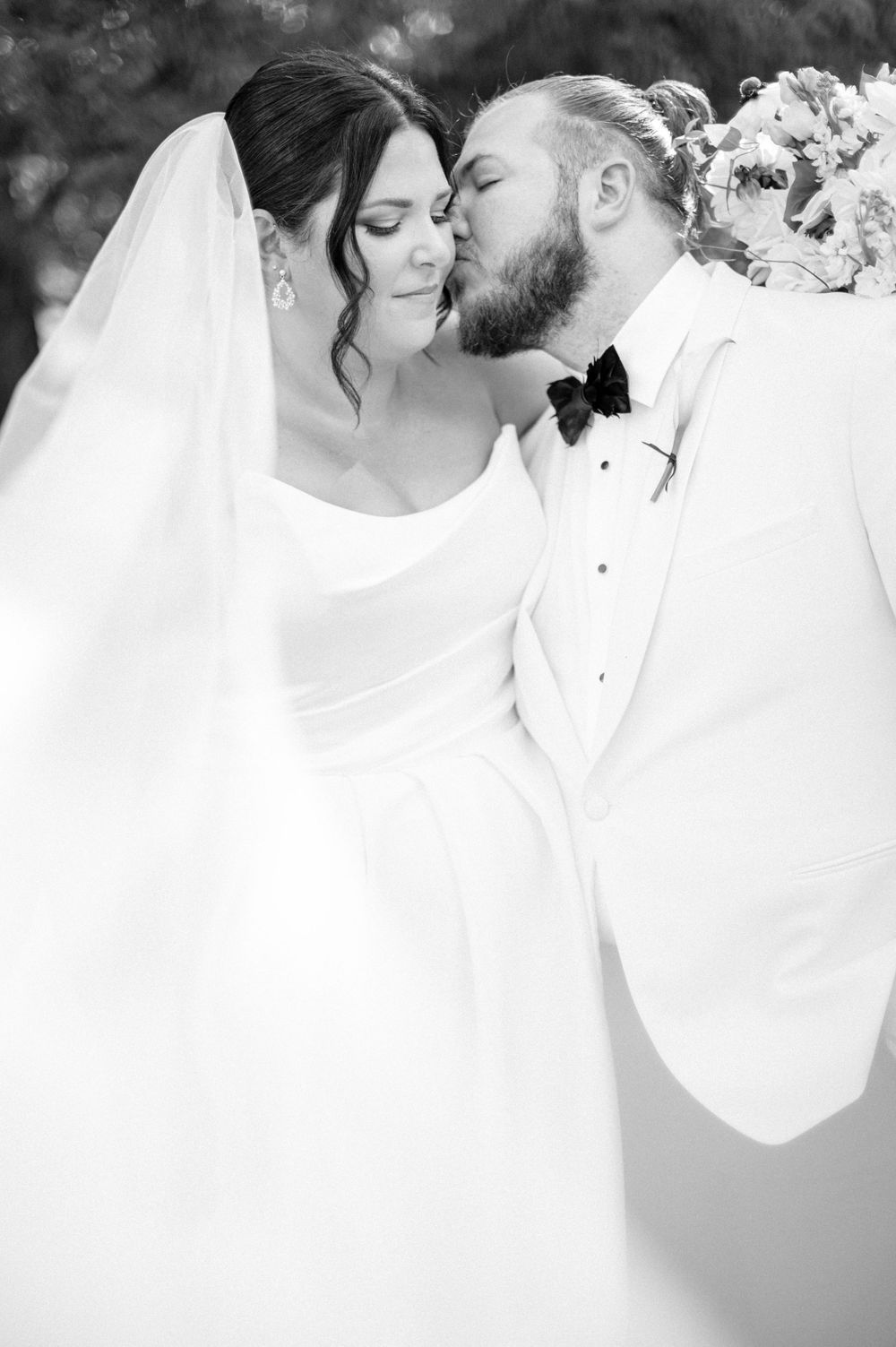 A romantic black and white wedding photo collage showing intimate moments between newlyweds in elegant attire.