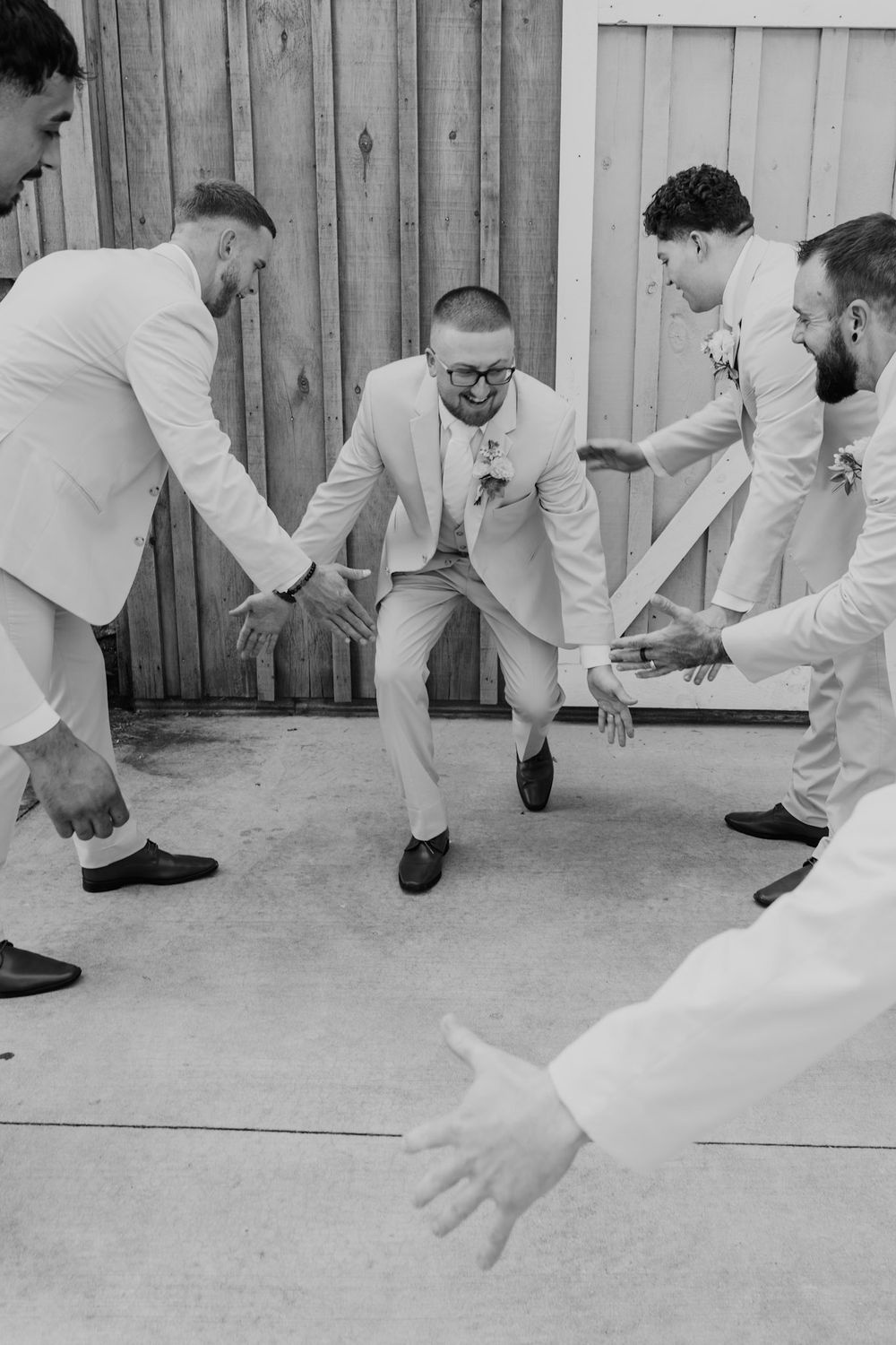 A sequence of black and white photos showing people in white suits playing a game of marbles on the ground.