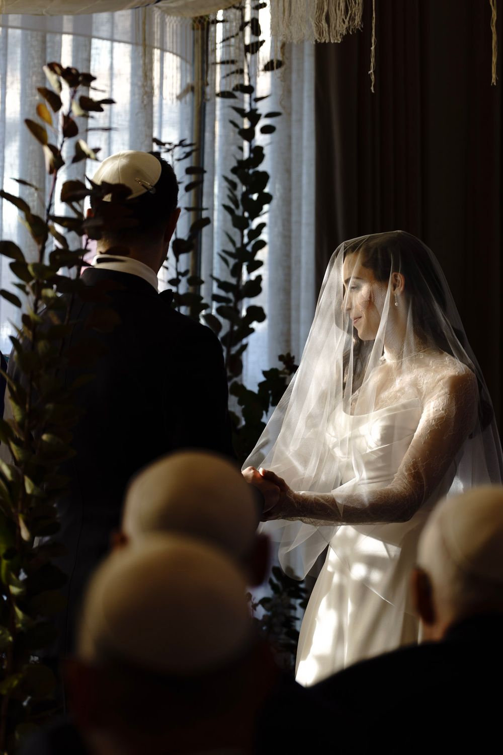 A sequence of wedding ceremony photos showing the bride and groom in silhouette against a bright window with foliage.