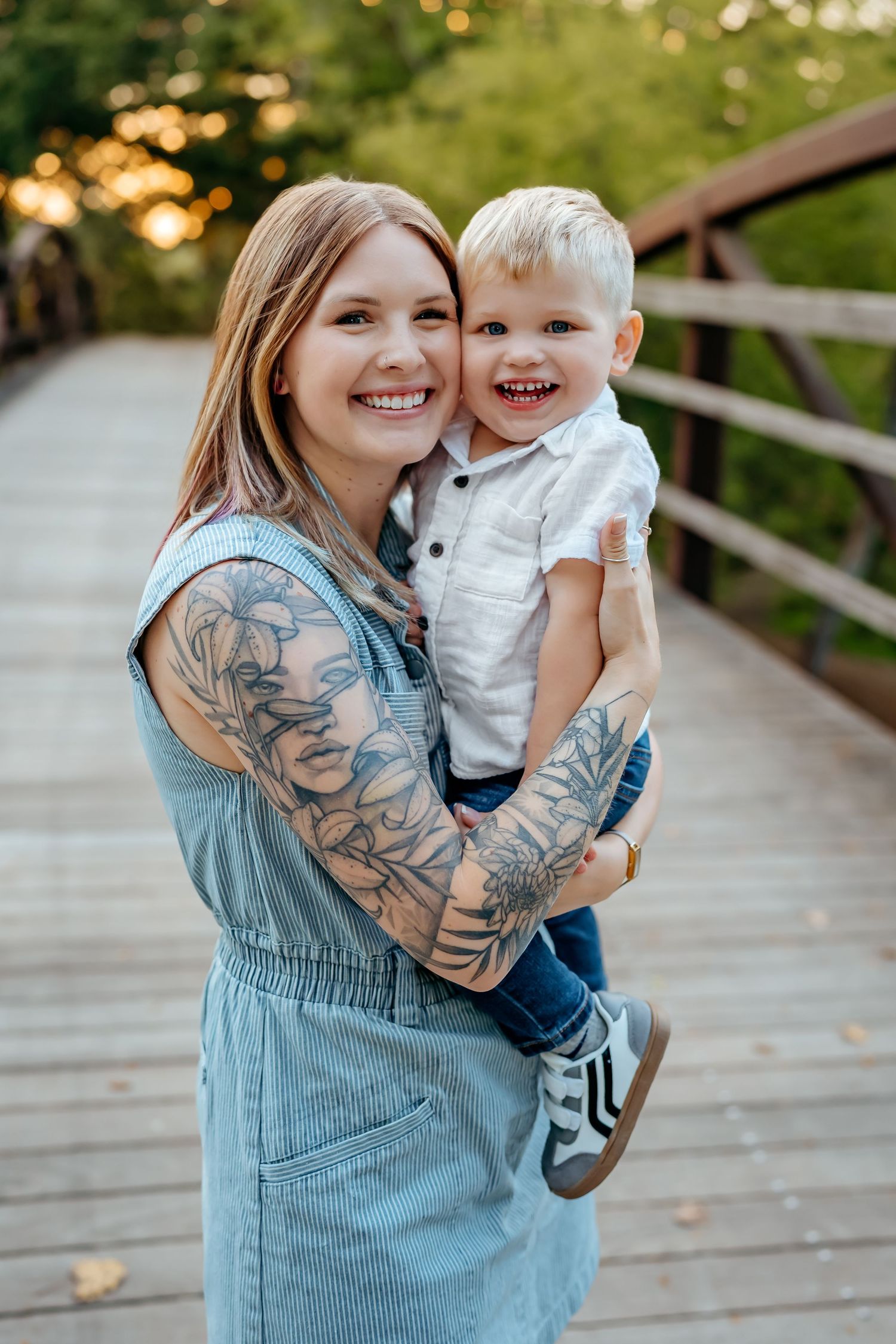 Parent and child share joyful moments together on a wooden bridge in an outdoor setting.