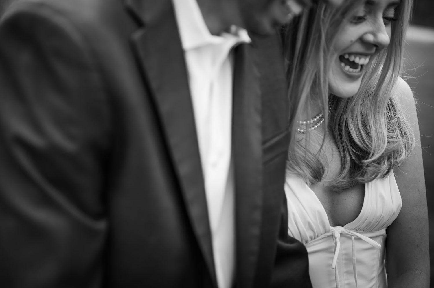 A series of black and white wedding photos showing candid moments between a couple in formal attire.