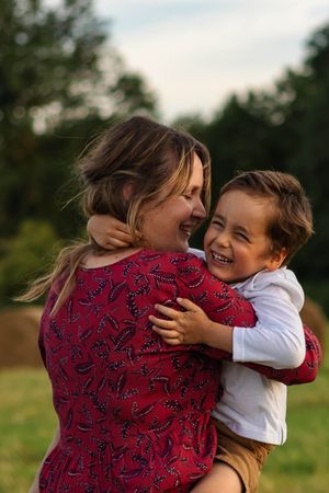 maman et son petit-garçon qui s'enlacent pendant une séance photo famille en extérieur à la campagne