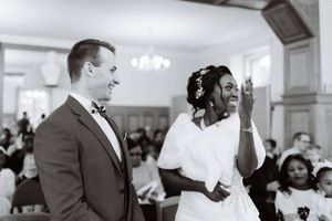mariée qui montre sa bague à tout le monde pendant que le marié l'admire et sourit