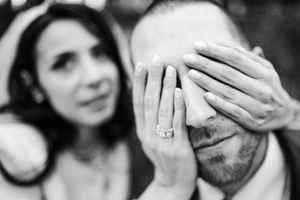 la mariée cache les yeux du marié avec ses mains dont les ongles indiquent le prénom de son amoureux