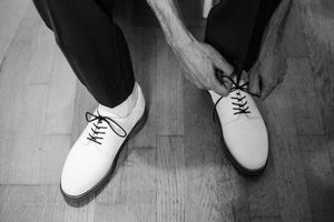 marié qui met les lacets de ses chaussures