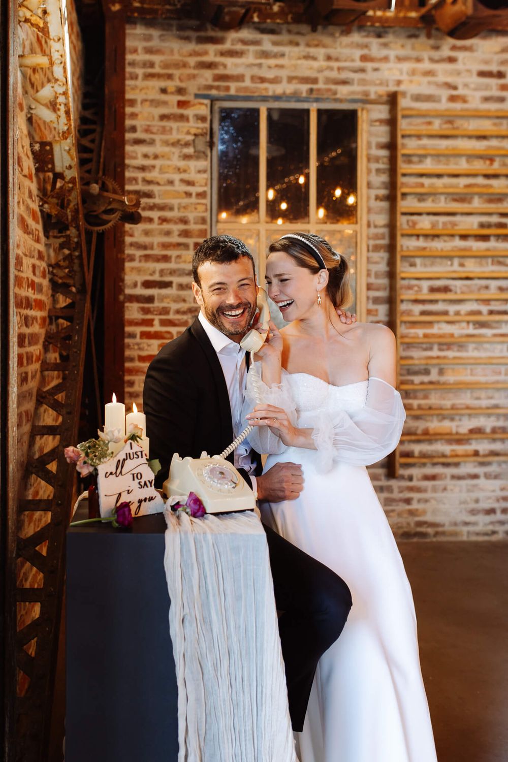mariés jouant avec leur déco de mariage téléphone rétro