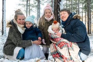 famille qui pose pendant une séance hivernale de noël dans un décor de forêt enneigée