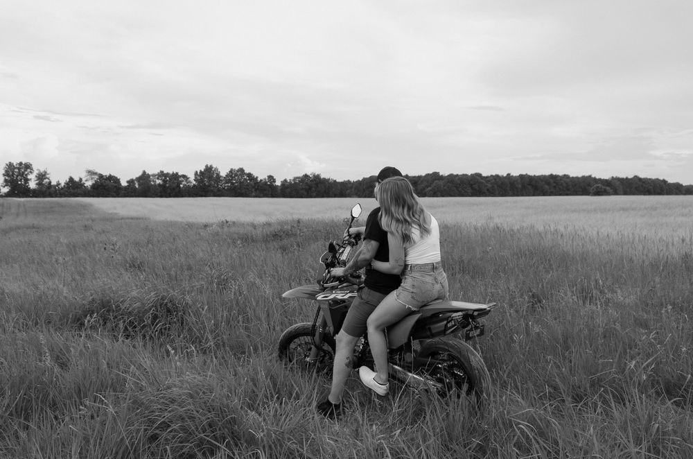 A sequence of black and white photos shows a motorcycle riding through tall grass in an open field.