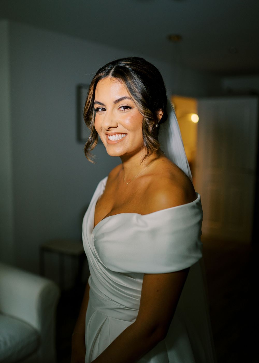 Dramatic portraits of bride in off-shoulder wedding dress with moody lighting.