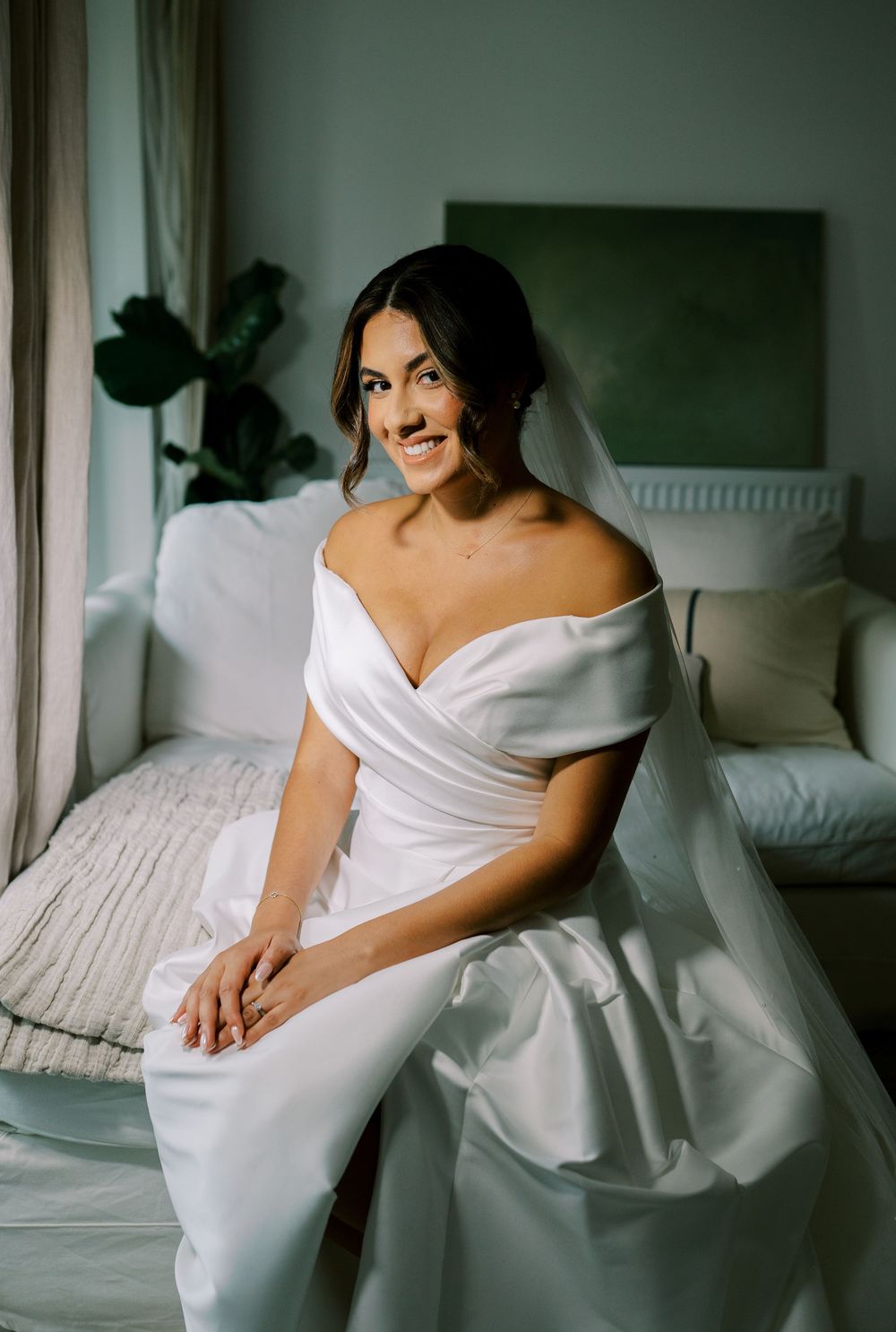 Candid bridal portraits on white bedding with natural window light.