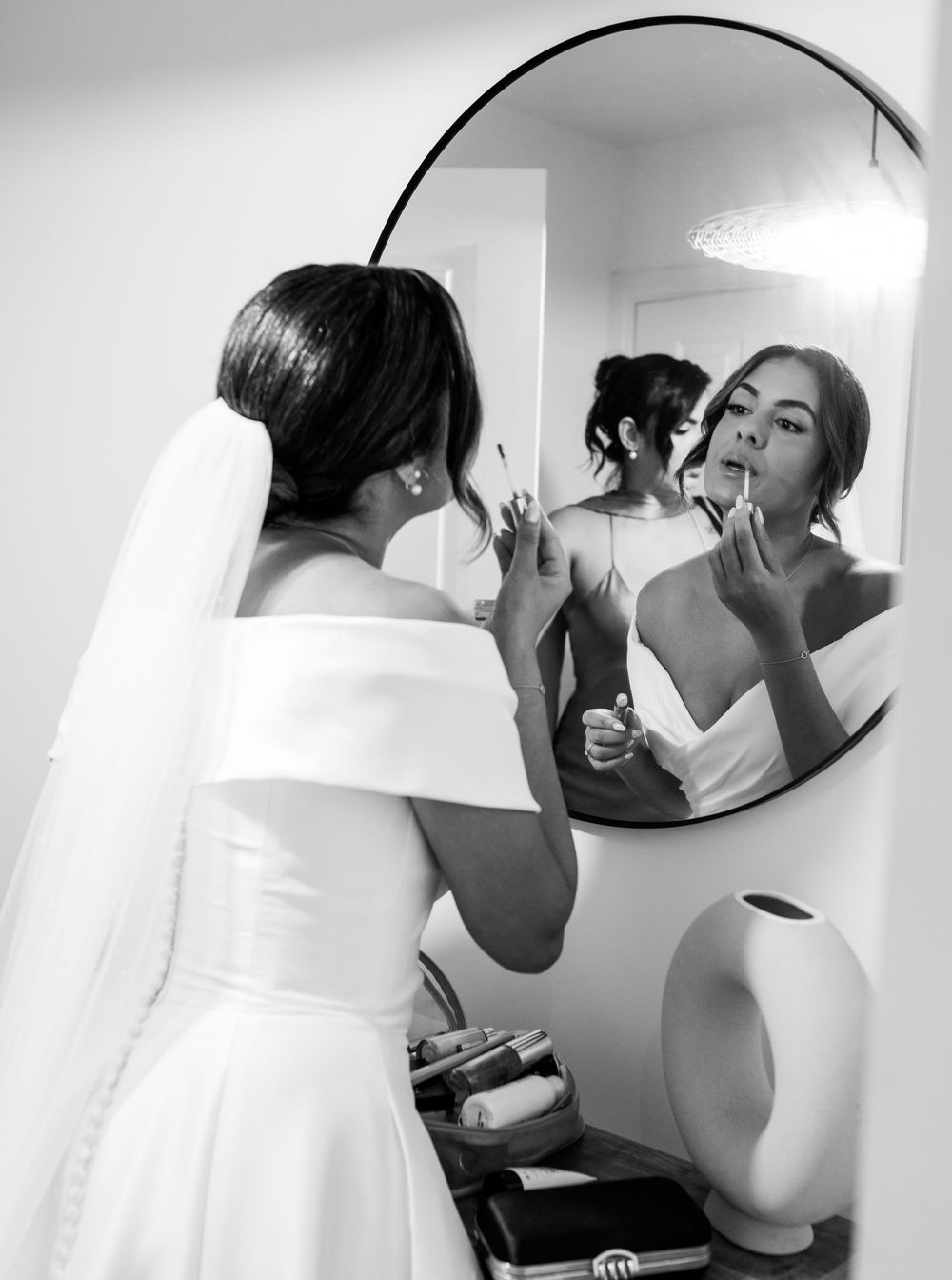 Wedding preparation scene reflected in mirror as bride gets ready.