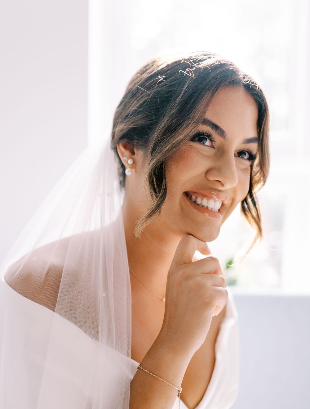 Candid bridal portrait with soft natural lighting and flowing veil.