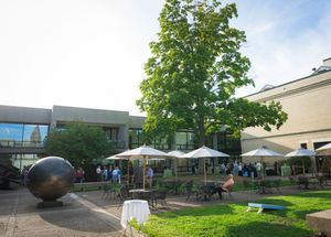 A series of five outdoor photos showing a modern building exterior with landscaping, walkways, and architectural features.