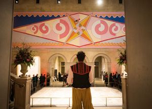 Ornate stage or performance space with decorative pink and white trim and arched architectural details.