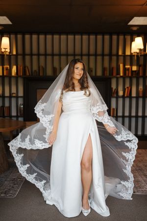 Wedding dress detail showing intricate lace veil and flowing white gown.