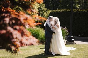 Autumn wedding portraits captured in a scenic outdoor garden setting with golden foliage.