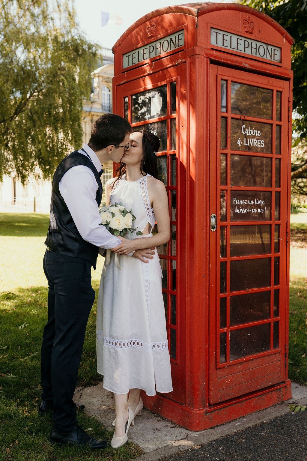 couple de mariés devant une cabine téléphonique
