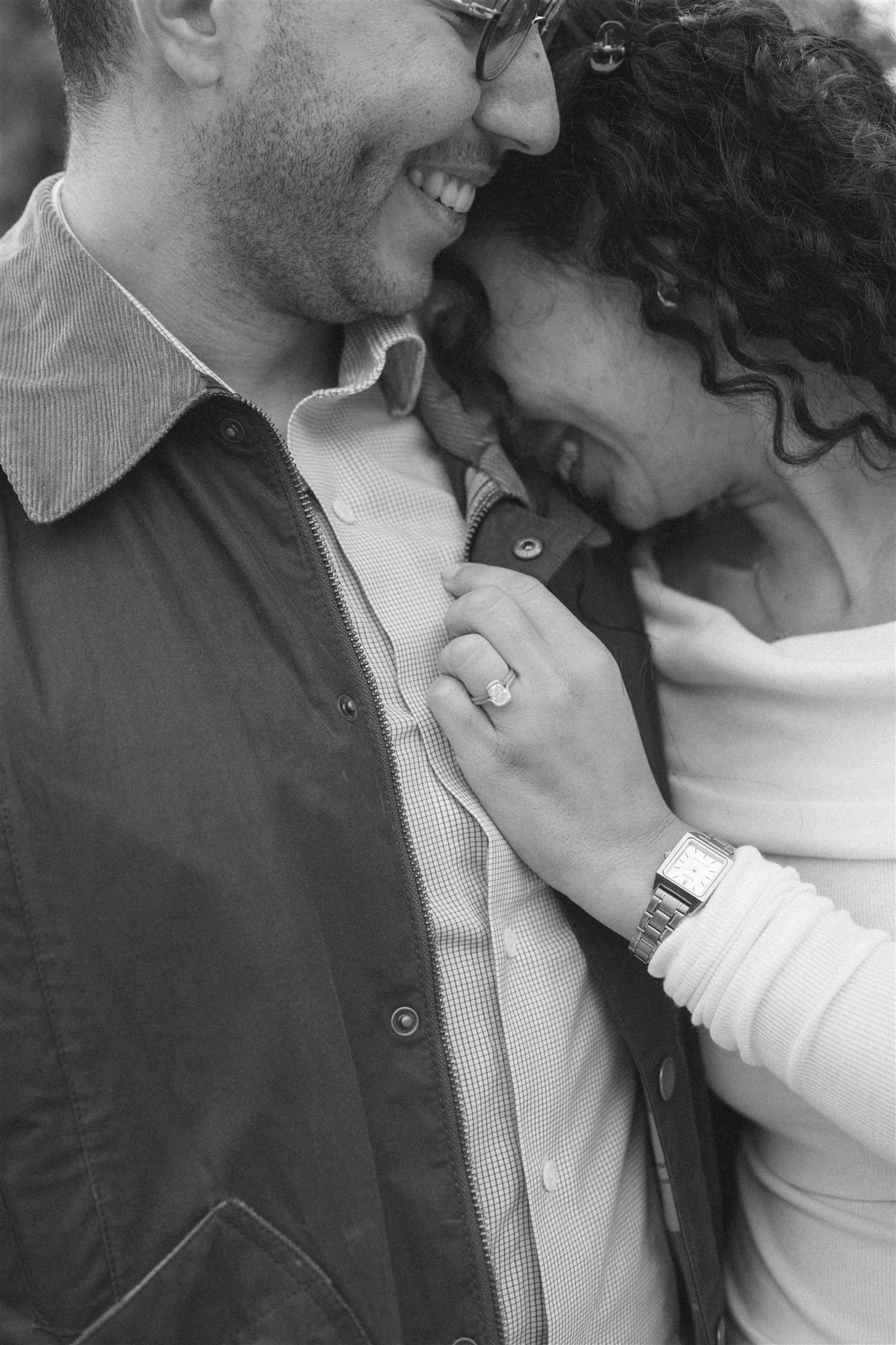 A romantic black and white photo showing intimate close-up of engagement ring