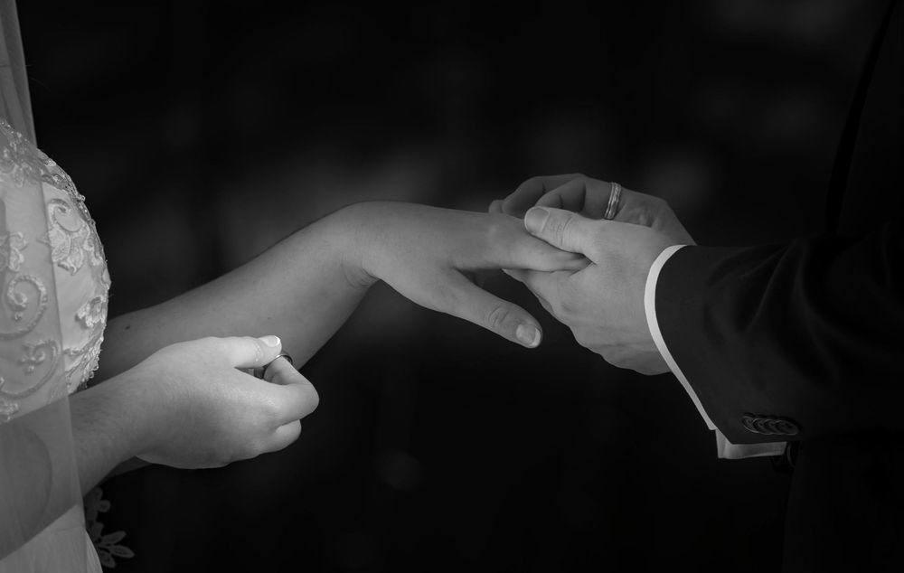 A dreamy black and white photo of a bride and groom exchanging rings at the Roberts Mansion in Spokane Washington