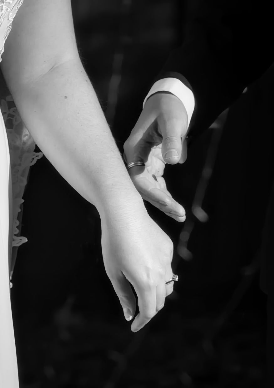 A black and white photo of a bride and groom holding hands at the Roberts Mansion in Spokane Washington.