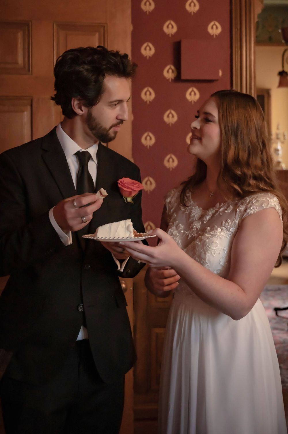 A bride and groom eating cake at their ceremony at the Roberts Mansion in Spokane Washington.