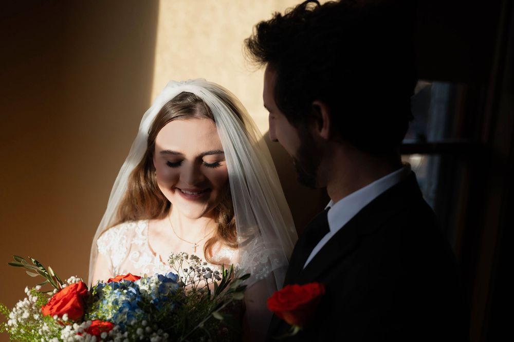 A dreamy photo of a bride and groom in the golden light of a window at the Roberts Mansion in Spokane Washington.