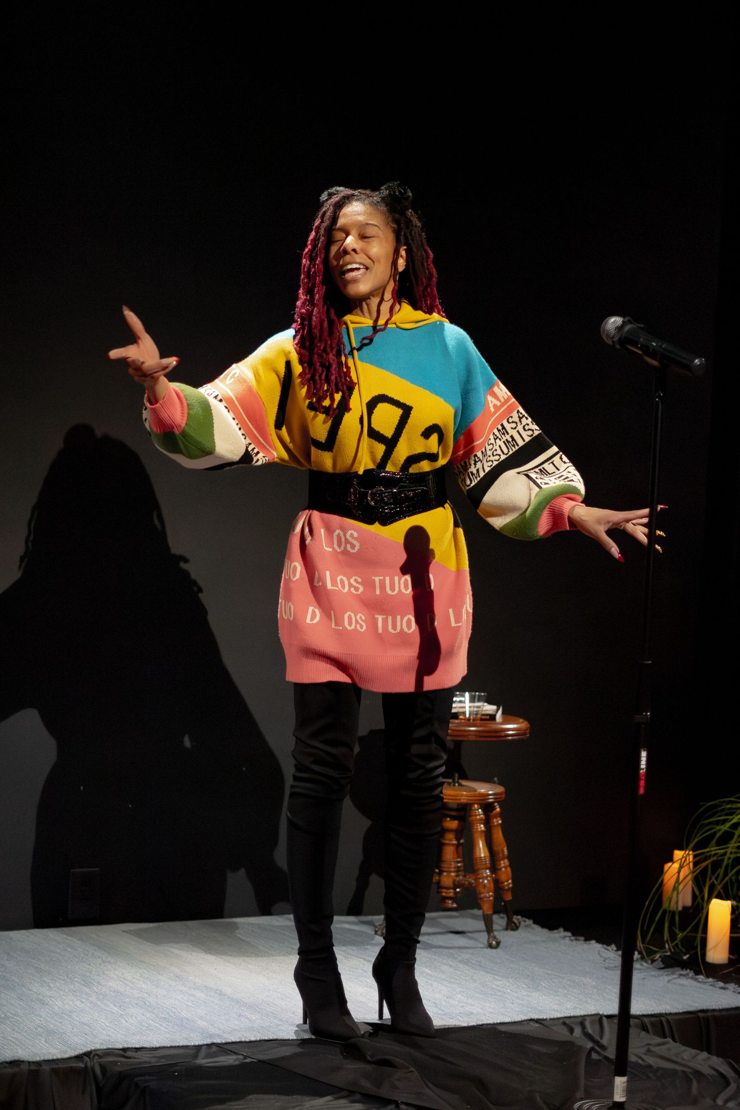 Energetic stage performance with colorful lighting and dramatic gestures.