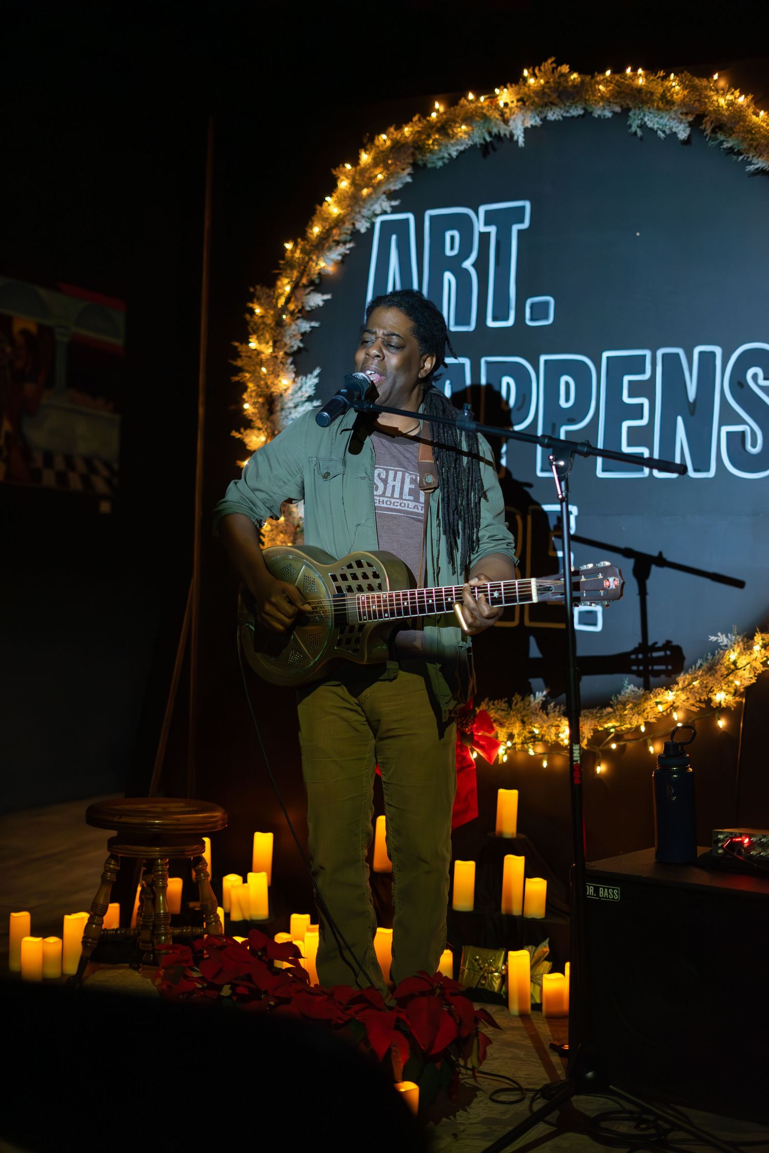 Musical performance at night with string lights and luminaries creating ambient atmosphere.