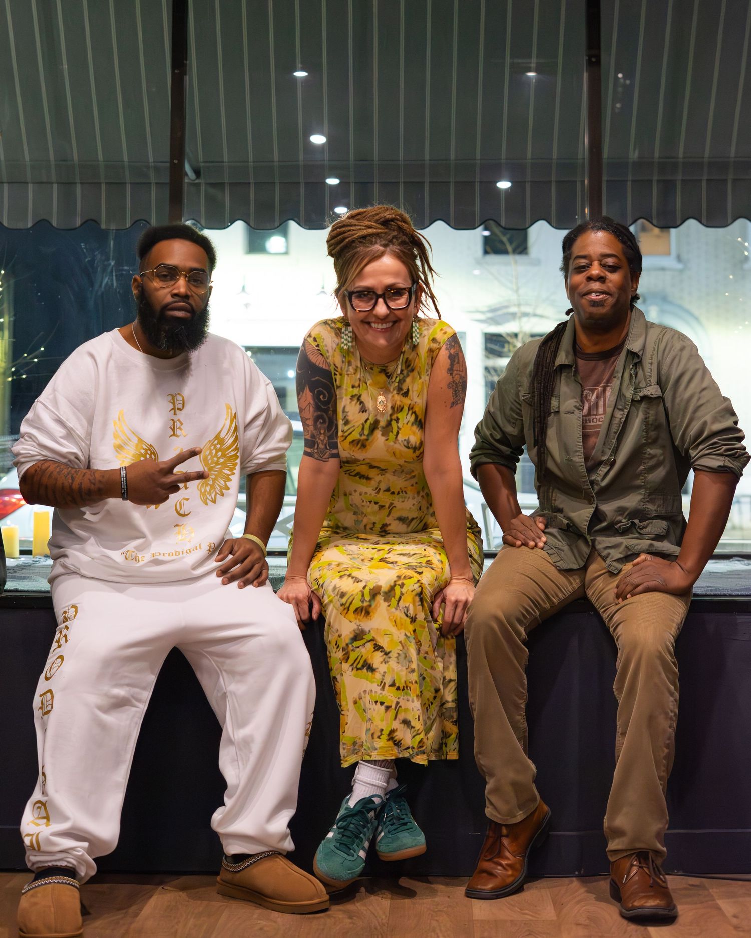 Group photo of performers sitting together on a bench in casual attire.