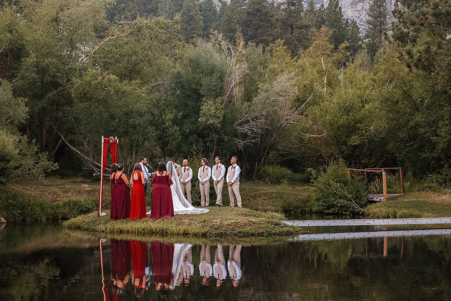Lakeside wedding venue with mountain backdrop and formal attire displayed.
