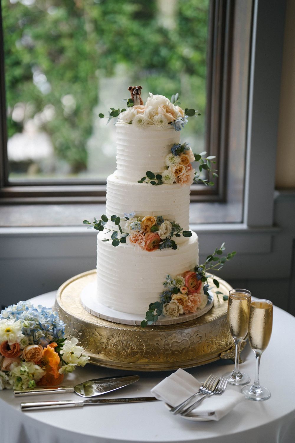 Elegant white wedding cake with delicate floral decorations displayed on a gold plate in multiple angles.
